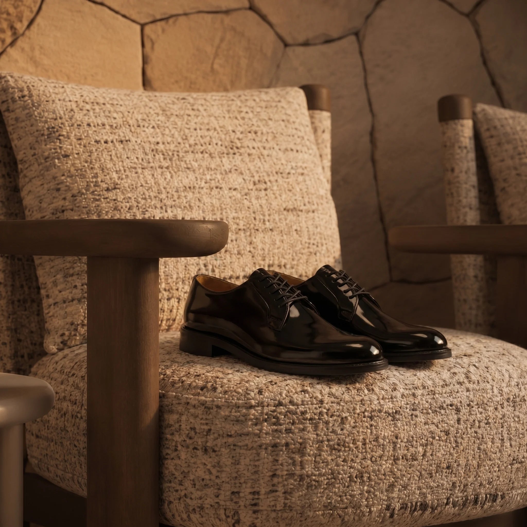 Hand-polished derby shoe in waxed full-grain leather placed on a luxurious armchair