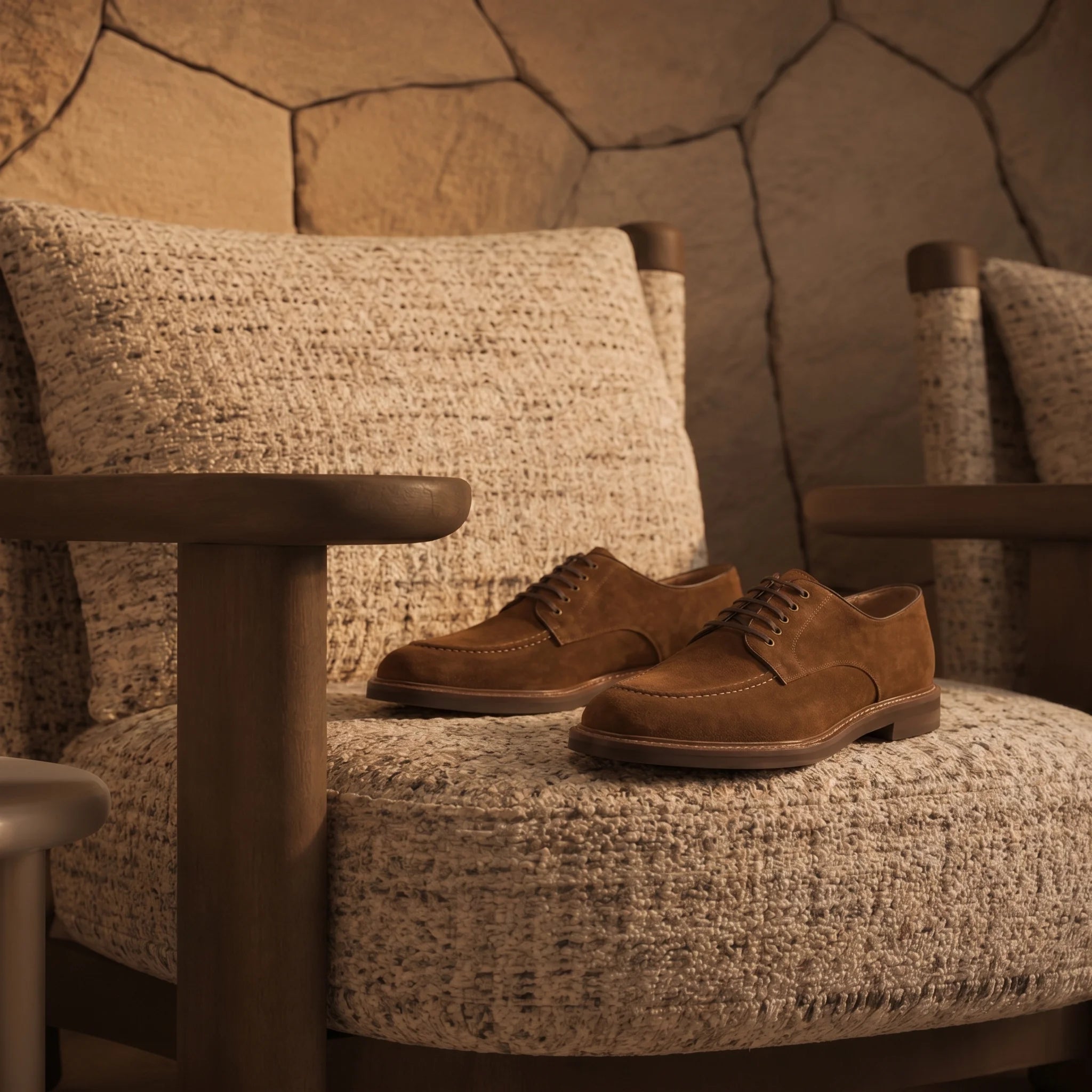 Handcrafted suede derby shoe placed on a chair in an elegant, luxurious room